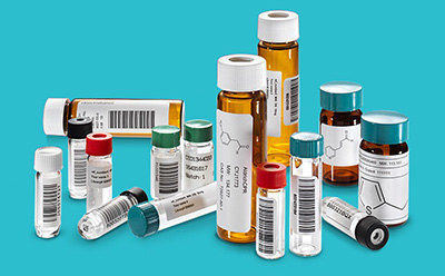 Aldrich Market Select Compound Library Access Assortment of labeled pharmaceutical vials and laboratory sample tubes arranged against a turquoise background.