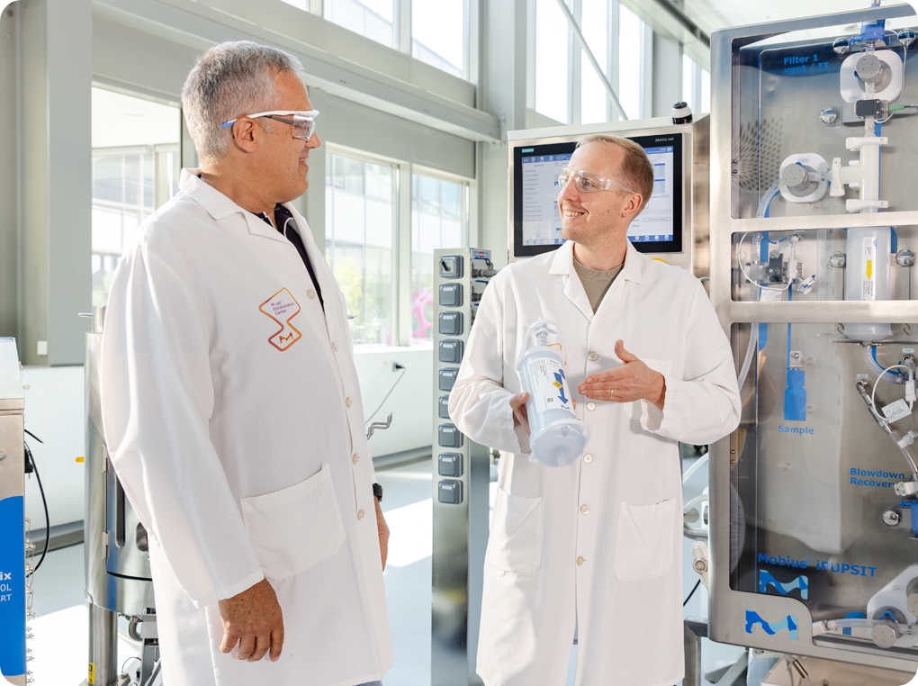 Sterile filtration design discussion Two process engineers discussing sterile filtration solutions holding a capsule.