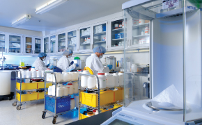 A photo showing three process development scientists seating at a bench in a lab to do formulation reviews and feasibility assessments for cell culture media.
