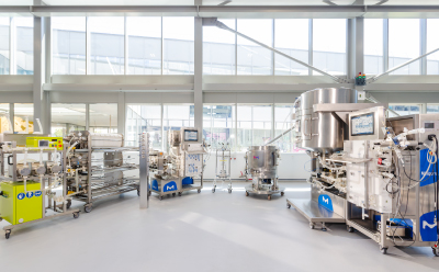 Image showing bioprocessing systems, including a clarification system and holder, a chromatography system and column, a single-use mixer and a TFF (tangential flow filtration) system, in a lab environment