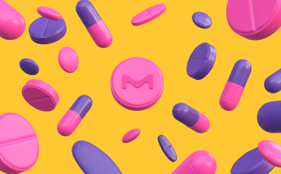 Various pink and purple pills and capsules scattered on a bright yellow background. One prominent round pink pill in the middle of the picture features the letter "M" embossed on it.