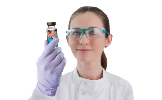 Sterile drug product 一位戴着防护眼镜的女科学家举起无菌药品