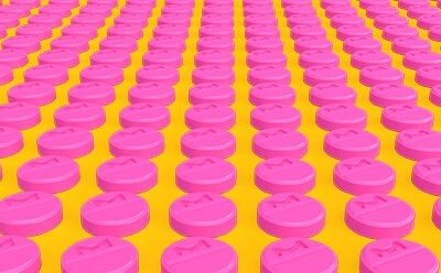 Rows of pink tablets representing a manufacturing environment.