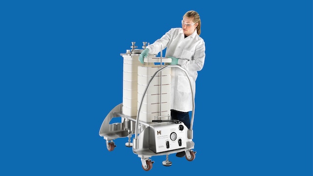 Scientist in a lab coat installing virus filters on a holder