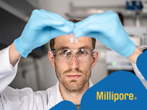 Laboratory scene with a scientist in protective gloves and safety goggles forming a heart shape with their hands; Millipore logo in the upper-left corner.