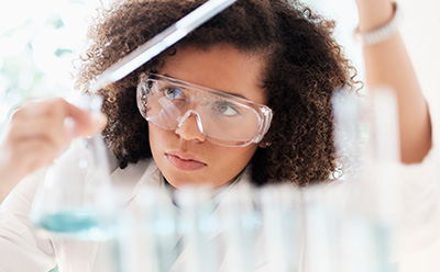 Woman in lab working with test tube and beaker