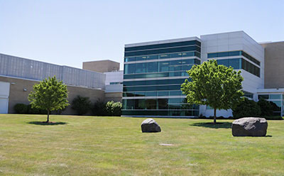 CDMO campus exterior in Wisconsin with brand signage — a leading US site for complex small-molecule pharmaceutical drug development and GMP manufacturing