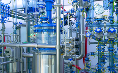 Close-up partial view of the Schaffhausen GMP pilot plant facility, featuring a 100-liter glass-lined reaction vessel and the glass-lined piping connected to and from the vessel.
