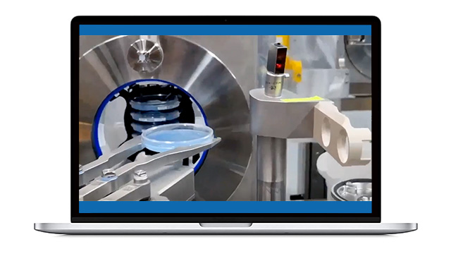 プレート分離の動画ポスター 製造現場における機械装置のクローズアップ。ロボットアームが丸い青い部品を扱っている様子が写っている。背景には光沢のある金属面と円形の開口部があり、ハイテクな環境を彷彿とさせる。この光景はノートパソコンの画面に映し出されている。