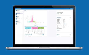 A laptop displaying a data analysis interface on a blue background. The screen shows a colorful graph with a prominent peak in pink, along with data tables below it highlighted in green, blue, and pink. On the left side, there are navigation options, and on the right side, there is a panel with detailed information about the analysis.