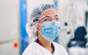Cell Therapy Scientist in full PPE working in contract testing lab