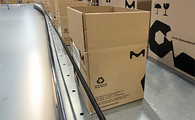 Boxes on conveyor belt, showcasing sustainable forestry-certified packaging at Darmstadt site.