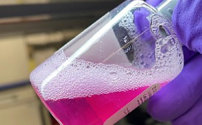 The product bottle of the rehydrated EDM gel, slanted and facing the top right corner. Fingers hold the bottle top. The product bottle of the rehydrated EDM gel, slanted and facing the top right corner. Fingers hold the bottle top.