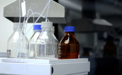 Mobile phase in bottles for High Performance Liquid Chromatography (HPLC) analysis Glass solvent reservoir bottles with blue caps and inlet tubing mounted on an HPLC system tray, representing the mobile phase setup for high-performance liquid chromatography