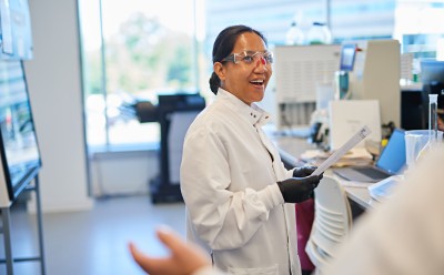 Sanger Sequencing Lab worker talking to a coworker.