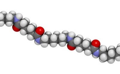 Nylon (nylon-6,6) plastic polymer, chemical structure - linear fragment Estructura química del polímero plástico nailon en la que los átomos están representados por esferas según el código de color convencional: hidrógeno (blanco), carbono (gris), oxígeno (rojo). Polímero plástico de nailon (nailon-6,6), estructura química - fragmento lineal.