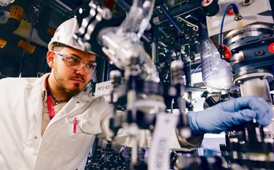 Manufacturing facility worker adjusting equipment, representing Merck's manufacturing workflow product offerings for medical device manufacturing. Manufacturing facility worker adjusting equipment, representing Merck's manufacturing workflow product offerings for medical device manufacturing.