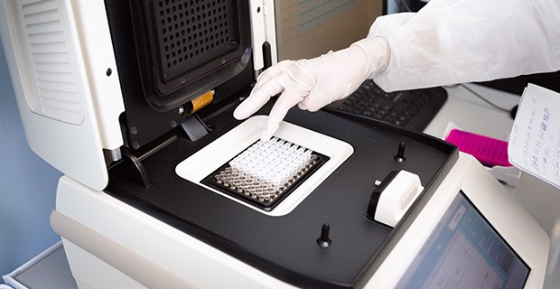 Raw Materials for Molecular Diagnostics DNA being placed into the PCR thermal cycler or amplifier for PCR diagnostics.