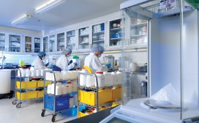 A photo showing three process development scientists seating at a bench in a lab to do formulation reviews and feasibility assessments for cell culture media.