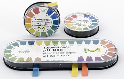Tres recipientes de tiras de papel indicador de pH, cada uno con un gráfico del intervalo de medición del pH codificado en colores, en la tapa. Los recipientes son redondos o alargados, uno está en posición horizontal y dos en vertical, todo ello sobre un fondo blanco. Cada recipiente tiene también un pequeño trozo de cinta adhesiva de varios colores que parecería que marcan los distintos intervalo de pH. Tres recipientes de tiras de papel indicador de pH, cada uno con un gráfico del intervalo de medición del pH codificado en colores, en la tapa. Los recipientes son redondos o alargados, uno está en posición horizontal y dos en vertical, todo ello sobre un fondo blanco. Cada recipiente tiene también un pequeño trozo de cinta adhesiva de varios colores que parecería que marcan los distintos intervalo de pH.