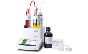 Configuración de valoración de laboratorio moderna con un valorador digital, varias botellas de reactivo transparentes una de las cuales contiene un líquido amarillo y una botella de color marrón oscuro con una etiqueta, todas conectadas por tubos, junto con una bandeja blanca con viales vacíos, lo que indica un proceso de análisis químico preciso. Configuración de valoración de laboratorio moderna con un valorador digital, varias botellas de reactivo transparentes una de las cuales contiene un líquido amarillo y una botella de color marrón oscuro con una etiqueta, todas conectadas por tubos, junto con una bandeja blanca con viales vacíos, lo que indica un proceso de análisis químico preciso.