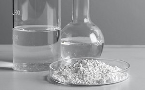 Material de vidrio del laboratorio y una placa de Petri que contiene una sustancia blanca.
