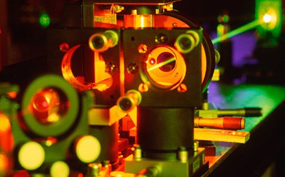 Optical components guiding laser pathway Imagen de los componentes ópticos que guían la trayectoria del láser a través del agujero de la maquinaria en la fábrica