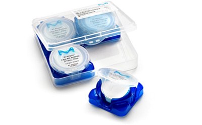 Millipore cut disc filter Comprimidos recién producidos en las manos enguantadas de un trabajador farmacéutico