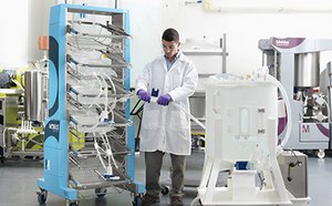 Técnico de laboratorio que conecta un conjunto de bolsas 2D sobre un carro contenedor Mobius® a una mezcladora Mobius®