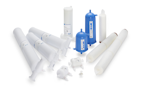 White and blue filters of different formats and sizes. On left of image are larger white T-line capsules while front center shows smaller white capsules for process development. Back center shows blue Opticap® XL capsules with cartridge filters on right side.