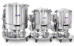 Tres biorreactores de acero inoxidable de diferentes tamaños en soportes con ruedas, cada uno con un logotipo ‘M’ azul y rosa en la parte delantera.