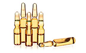 La imagen muestra una colección de cinco pequeñas ampollas de vidrio que contienen un líquido amarillo dorado. La imagen muestra una colección de cinco pequeñas ampollas de vidrio que contienen un líquido amarillo dorado.