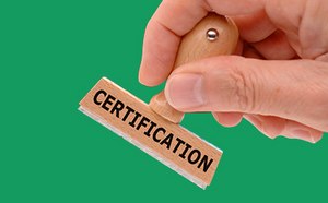 La imagen representa una mano dispuesta a estampar un sello de madera que indica «CERTIFICATION» («CERTIFICACIÓN») contra un fondo verde vibrante.