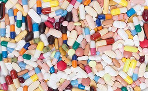 Colección variada de pastillas y cápsulas farmacéuticas. Las hay de varias formas y colores, como rosa, amarillo, blanco, azul y rojo. Algunas cápsulas son transparentes u opacas con los extremos de diferente color.