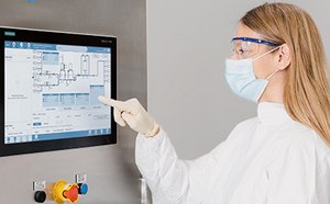 Scientist at a CoPrime Biochromatography unit operation using the HMI to interact with CCP® control software to adjust the system's parameters.