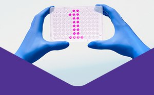 Two hands in blue gloves are showing a number 1 formed by pink tablets.