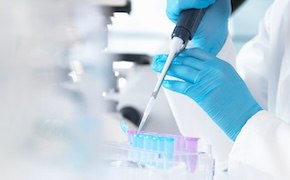 Scientist in a lab working with samples and an electronic pipette