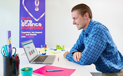 Cloud Services for the Millicell<sup>®</sup> ERS 3.0 Scientist sitting at a desk in an office, looking at data on a laptop computer.