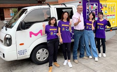 SPARK™ volunteers posing in front of company branded van.