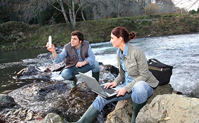 Photomertry at a River Dos científicos analizando el agua en un río.