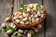 Bowl with pistachios on a wooden table. A bowl of pistachios.