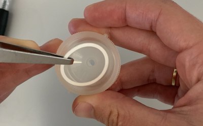 Swinnex<sup>®</sup> Filter Device O-ring Placement Fotografía de las manos de una persona usando pinzas para colocar la junta tórica dentro del dispositivo Swinnex®.