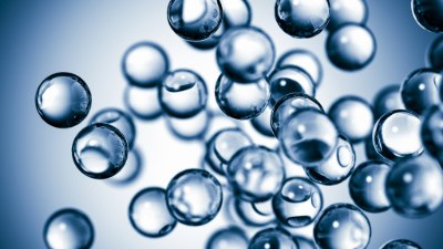 Gas bubbles dissolved in water A close-up view of transparent bubbles floating against a soft blue background, creating a sense of depth and movement
